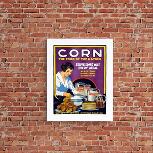 May include: A vintage-style poster titled CORN THE FOOD OF THE NATION, featuring a person preparing food with cans of corn meal, grits, and hominy. The illustration includes a plate of muffins, a stack of pancakes, and a pitcher of syrup.