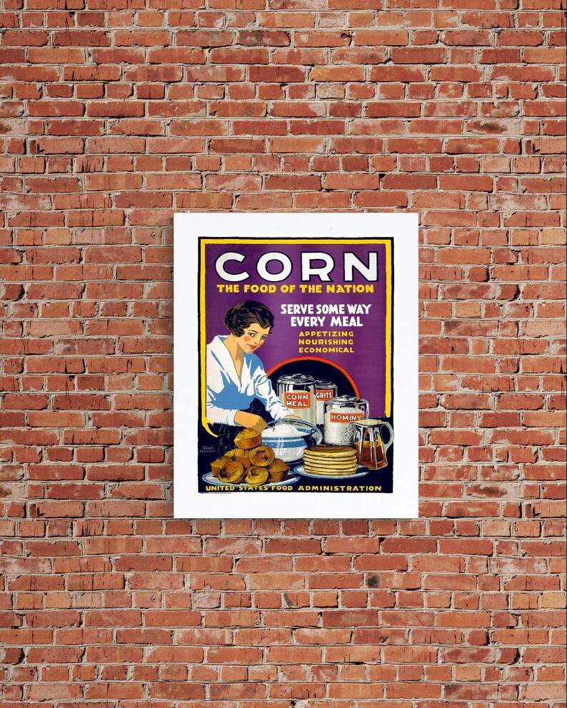 May include: A vintage-style poster titled CORN THE FOOD OF THE NATION, featuring a person preparing food with cans of corn meal, grits, and hominy. The illustration includes a plate of muffins, a stack of pancakes, and a pitcher of syrup.