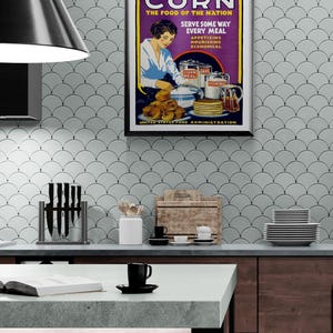 May include: A framed vintage poster titled CORN THE FOOD OF THE NATION, featuring an illustration of a person preparing corn-based dishes. The text includes SERVE SOME WAY EVERY MEAL, APPETIZING NOURISHING ECONOMICAL, and UNITED STATES FOOD ADMINISTRATION.