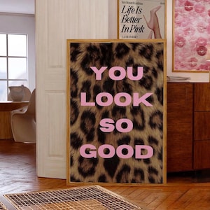 May include: A framed print with a leopard print background and the words "YOU LOOK SO GOOD" in pink letters.