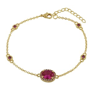 Könnte beinhalten: Goldfarbenes Armband mit Kettendesign. Es verfügt über einen zentralen ovalen, rubinroten Stein, der von kleineren, passenden Steinen umgeben ist. Zusätzliche rubinrote Steine sind entlang der Kette angeordnet. Das Armband hat einen Hummerverschluss.