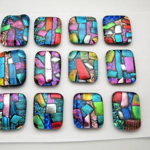 May include: Twelve colorful dichroic glass squares with a mosaic-like appearance. Each square features a unique pattern of blues, greens, pinks, and oranges, creating a vibrant and textured effect. These decorative glass pieces are ideal for jewelry making or craft projects.