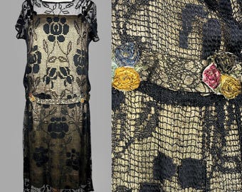 May include: A black and gold lace dress with floral embroidery. The dress has a fitted bodice and a flowing skirt. The lace is delicate and intricate, and the embroidery is colorful and eye-catching.