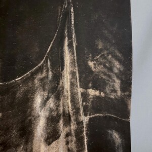 Puede incluir: Primer plano de una tela de terciopelo marr&oacute;n oscuro con un brillo sutil. La tela tiene un aspecto suave y texturizado con pliegues y arrugas visibles. La imagen resalta la textura lujosa y el color intenso del material.