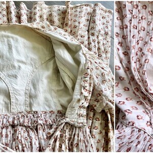May include: A vintage white cotton dress with a floral print in shades of brown. The dress has a gathered neckline and a fitted bodice. The dress is unlined and has a simple, classic design.