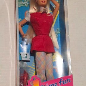 May include: A vintage "Schooltime Fun Barbie" doll in its original packaging. The doll wears a red dress and patterned tights. The box is pink and features the words "Special Edition".