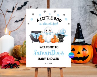 Puede incluir: Un letrero blanco sobre un caballete con el texto "A LITTLE BOO is almost due!" y "WELCOME TO Samantha's BABY SHOWER". El letrero presenta ilustraciones de un fantasma, calabazas, un gato negro y un caldero. Tema de baby shower de Halloween.