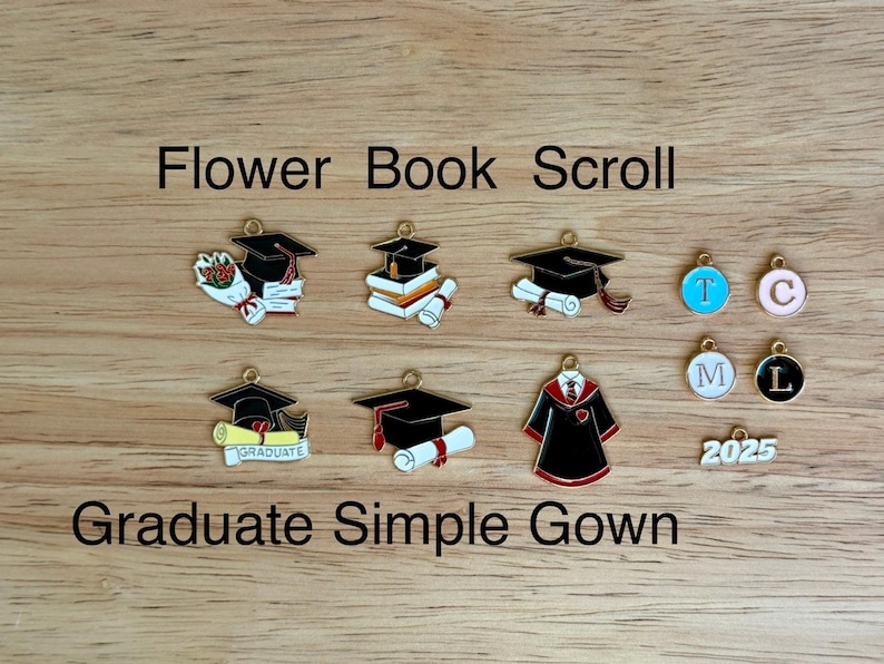 K&ouml;nnte beinhalten: Eine Sammlung von Charms zum Thema Abschluss, darunter Doktorh&uuml;te, Schriftrollen, B&uuml;cher und eine Robe. Einige Charms haben die Buchstaben T, C, M und L. Der Text "Flower Book Scroll" und "Graduate Simple Gown" ist ebenfalls sichtbar.