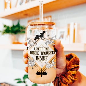 May include: A glass tumbler with a bamboo lid and a straw. The tumbler has a graphic of a dragon and clouds with the text "I kept the inside thoughts inside".
