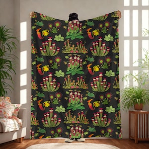 May include: A black throw blanket with a repeating pattern of colorful carnivorous plants. The design includes pitcher plants, sundews, and other botanical illustrations in shades of green, red, and yellow.