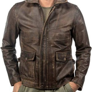 Könnte beinhalten: Eine braune Lederjacke mit Reißverschluss und zwei großen Taschen. Die Jacke hat einen Used-Look und einen Stehkragen.