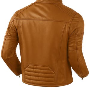 Op de afbeelding: Bruine leren jas met een klassiek ontwerp. De jas heeft een gewatteerd achterpaneel en schouderdetails. De mouwen hebben ritsen bij de manchetten. De jas heeft een warme, middellange bruine kleur.