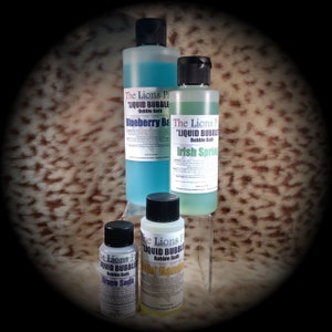 May include: Four bottles of "Liquid Bubble" bubble bath in different scents: Blueberry, Irish Spring, Grape Soda, and  "Bubba" Banana. The bottles are clear plastic with black caps and white labels.