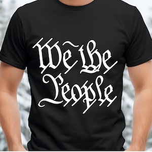 May include: Black t-shirt with white text that reads "We the People" in a stylised font.