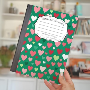May include: A composition book with a green cover patterned with red, pink, white, and green hearts. The cover features a white label that reads "COMPOSITION BOOK". The book measures 9.75 x 7.5 inches (24.7cm x 19cm) and contains 100 sheets.