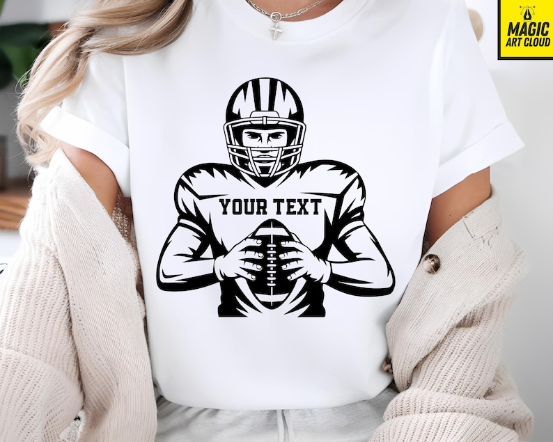 Puede incluir: Camiseta blanca con un gr&aacute;fico en blanco y negro de un jugador de f&uacute;tbol americano con casco, sosteniendo un bal&oacute;n de f&uacute;tbol. El texto "YOUR TEXT" se muestra en el pecho del jugador.
