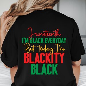 May include: Black t-shirt with the text "Juneteenth" in red script, followed by "I'M BLACK EVERYDAY" in green, "But Today I'm" in yellow, and "BLACKITY BLACK" in red and green. The shirt is a casual style.