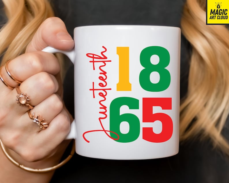May include: White ceramic mug featuring the word "Juneteenth" in red script, and the numbers "18" in yellow and green, and "65" in red. The mug has a white handle and is held by a person.