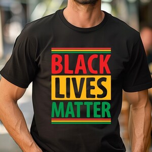 May include: Black t-shirt with the words "BLACK LIVES MATTER" in red, yellow, and green. The text is arranged in a rectangular design. The shirt is a crew neck style.