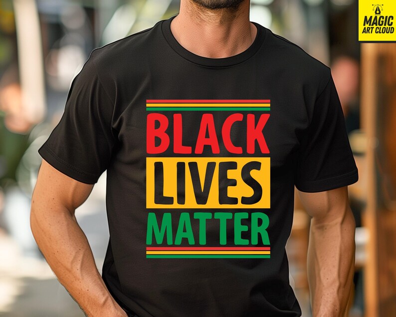 May include: Black t-shirt with the words "BLACK LIVES MATTER" in red, yellow, and green. The text is arranged in a rectangular design. The shirt is a crew neck style.