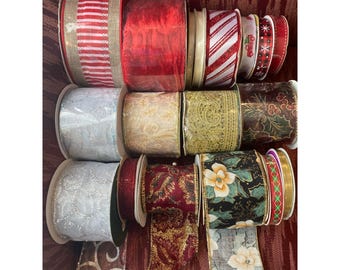 May include: A collection of decorative ribbon spools in various colors and patterns. Includes red, white, gold, and green ribbons with designs such as stripes, floral, and holiday motifs. Perfect for crafting and gift wrapping.