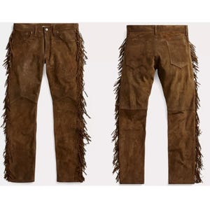 Puede incluir: Pantalón de ante marrón con detalles de flecos a los lados. El pantalón tiene un corte recto y un diseño clásico de cinco bolsillos.