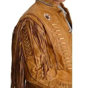 May include: A brown leather jacket with fringe detailing and beaded accents. The jacket has a zipper closure and a stand-up collar.