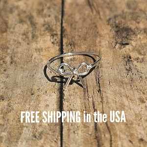 May include: A silver ring with a bow design. FREE SHIPPING in the USA.