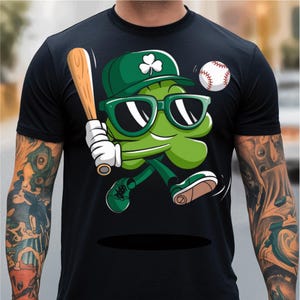 May include: A black t-shirt featuring a green cartoon shamrock wearing sunglasses and a baseball cap, holding a baseball bat and running with a baseball in the air.