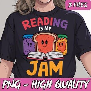 以下が含まれることがあります： カラフルな文字で「Reading is my jam」と書かれた黒いTシャツ。デザインは、顔が付いたジャムの瓶が3つ付いた本です。瓶は紫、オレンジ、赤です。