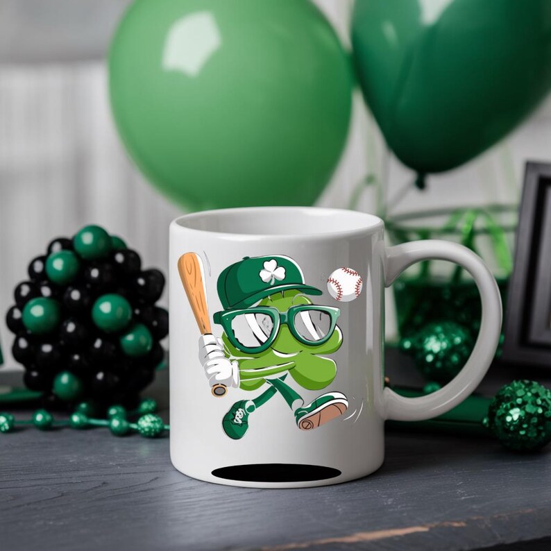 May include: White ceramic mug featuring a green shamrock cartoon character wearing sunglasses and a baseball cap, holding a baseball bat and a baseball. The shamrock is sporting a green and white baseball uniform. The mug has a black handle.