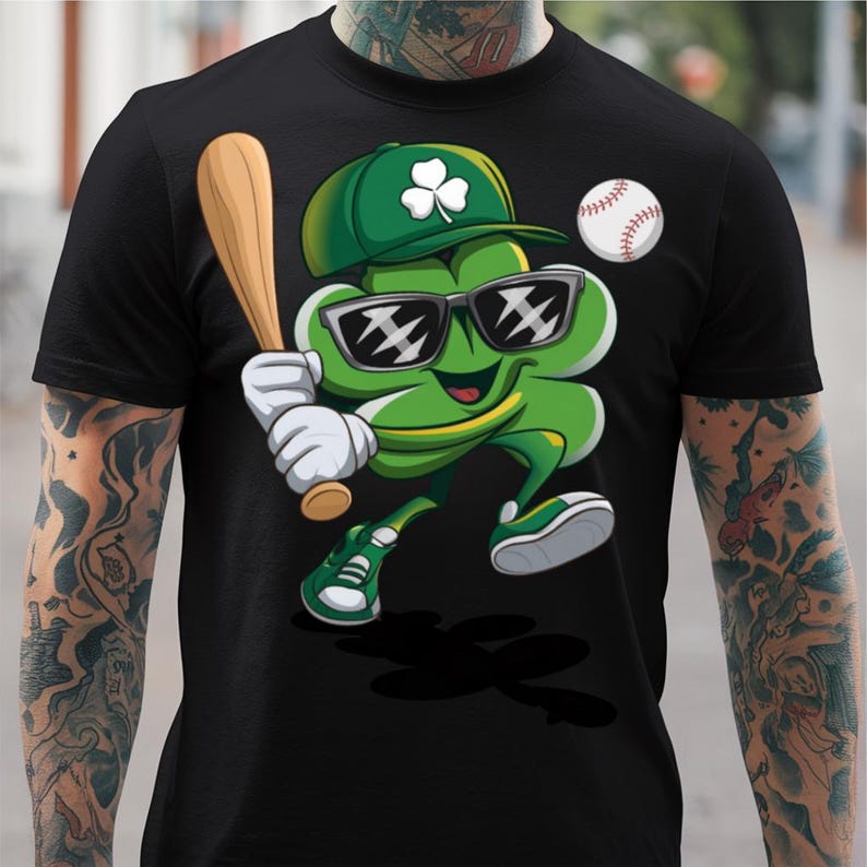May include: A black t-shirt featuring a green cartoon shamrock wearing sunglasses and holding a baseball bat. The shamrock is wearing a green and white baseball cap with a shamrock on it. A baseball is in the background.
