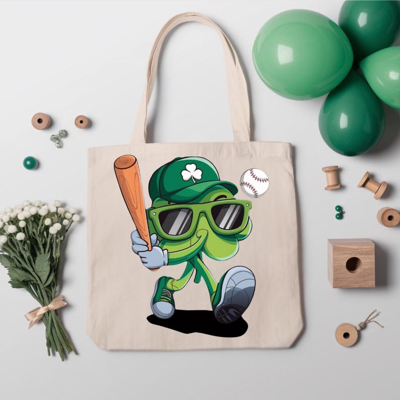 May include: A white canvas tote bag featuring a green shamrock character wearing a baseball cap, sunglasses, and holding a baseball bat. The shamrock is holding a baseball in its hand. The bag has a green shamrock design on the front.