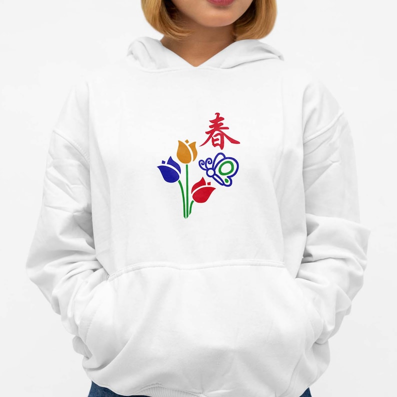 May include: White hoodie featuring a colorful floral and butterfly design with the Chinese character for "spring". The graphic includes blue, yellow, and red tulips with green stems. The design is centered on the front of the hoodie.