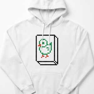 Könnte beinhalten: Weißer Kapuzenpullover mit einem pixeligen Enten-Design. Die Ente ist grün und rot, innerhalb eines schwarz umrandeten Rechtecks. Der Hoodie hat einen Kordelzug und eine Vordertasche. Das Design erinnert an Retro-Videospiele.
