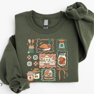 a green sweatshirt with a picture of a cat on it