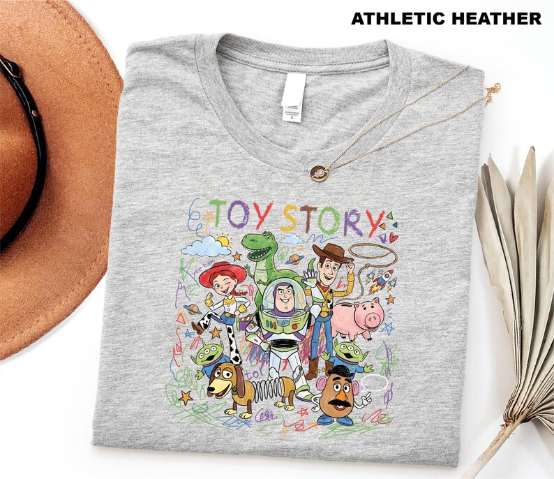 A gray t-shirt with a colorful graphic design featuring characters from the Toy Story movie, including Woody, Buzz Lightyear, and other beloved characters.