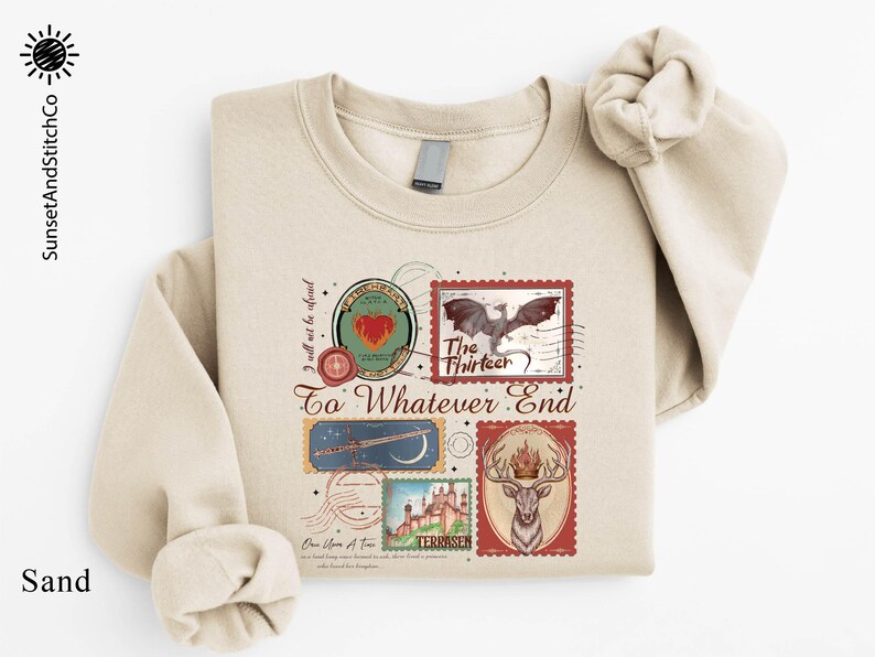 A beige sweatshirt with a printed design featuring various elements such as a bird, a castle, and a heart.