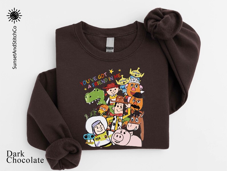 A dark brown sweatshirt with a colorful graphic of various cartoon characters from the Toy Story franchise, including Woody, Buzz Lightyear, and other beloved characters.