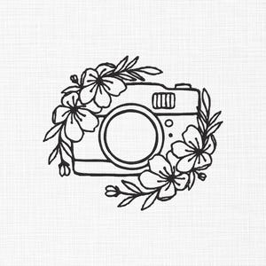 May include: Black and white line drawing of a vintage camera with flowers around it.