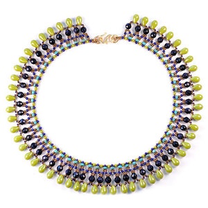 Puede incluir: Un collar de cuentas con un cierre de oro. El collar está hecho con cuentas verdes, azules y negras en un patrón geométrico.