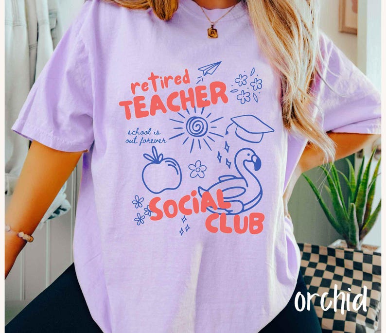 May include: A light purple t-shirt with the words "retired TEACHER SOCIAL CLUB" in red and blue. The shirt has a graphic of a sun, apple, flamingo, and other small illustrations. The word "orchid" is written in white at the bottom right.