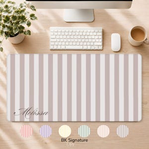 Peut inclure: Un tapis de bureau rectangulaire avec un motif de rayures verticales alternant entre le blanc et le mauve poussiéreux. Le prénom Melissa est imprimé en écriture cursive gris foncé dans le coin inférieur gauche. Six petits échantillons de couleur circulaires sont affichés en dessous.