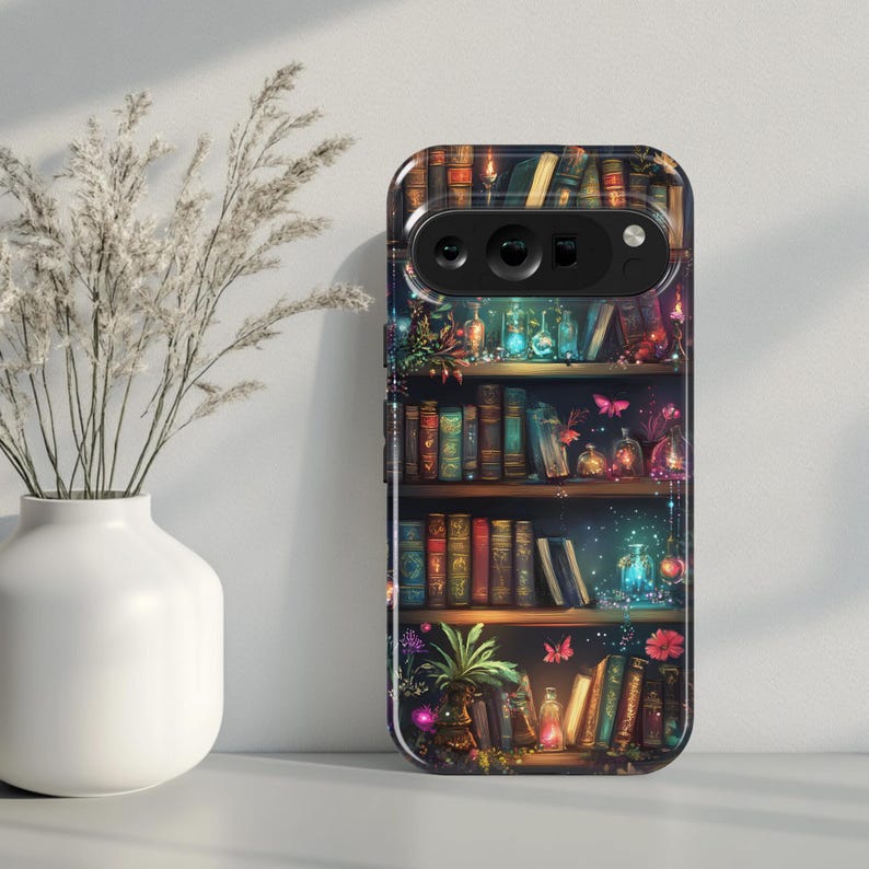 May include: A phone case with a detailed illustration of a bookshelf filled with books, glowing bottles, and plants. The case has a dark background with colourful accents, creating a fantasy theme.