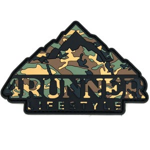 May include: A black and camouflage patch in the shape of a mountain range. The word "RUNNER" is in bold, cut-out letters, and the words "LIFESTYLE" are below. The mountain design features shades of green, brown, and tan.