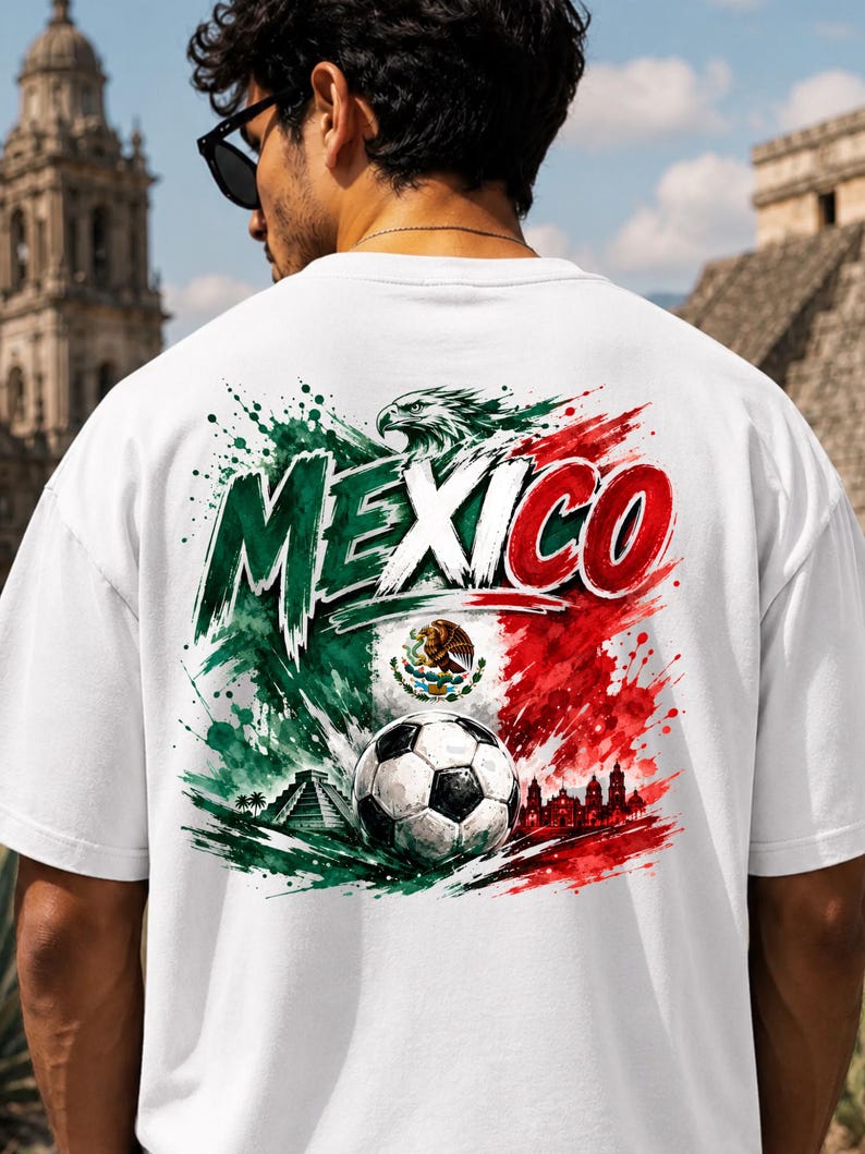 K&ouml;nnte beinhalten: Ein wei&szlig;es T-Shirt mit einer gro&szlig;en Grafik auf der R&uuml;ckseite, die das Wort MEXICO in fetten Buchstaben zeigt. Das Design umfasst einen Fu&szlig;ball, die mexikanische Flagge, einen Adler, eine Pyramide und eine Skyline im Farbklecks-Stil.