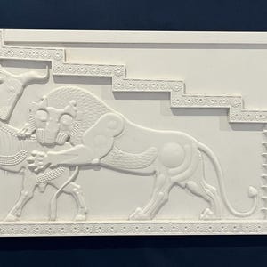 May include: White plaster relief sculpture depicting a lion attacking a horse. The sculpture is framed with a decorative border and features a stylized staircase in the background.