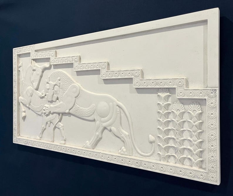 May include: White plaster relief sculpture depicting a stylized lion attacking a horse. The sculpture is framed with a decorative border and set against a plain white background.
