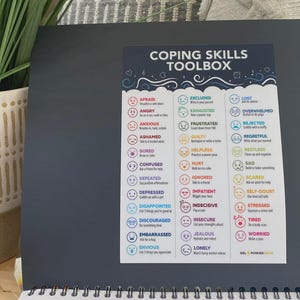May include: A colorful "Coping Skills Toolbox" chart with various emotions and corresponding actions. The chart includes words like "Afraid," "Angry," and "Anxious," with suggestions such as "Write in your journal" and "Take a power nap."