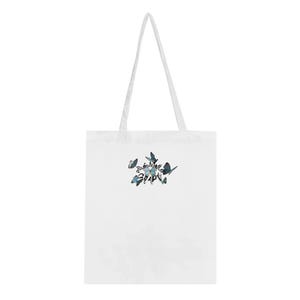 May include: White tote bag with a design of blue butterflies in a circular pattern.